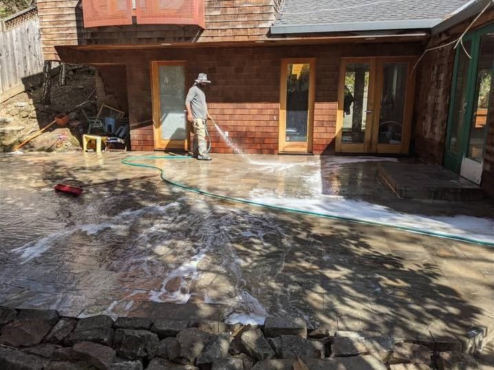picture of backyard deck getting pressure washed